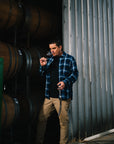 Ben tastes a barrel sample of the Blind Corner Bernard - Organic and Biodynamic Preservative Free Margaret River Cabernet. He stands in front of a stack of barrels and holds a glass in one hand, the barrel thief in another.