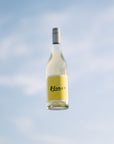 A bottle of wine labeled 'Blanc' against a sky background.