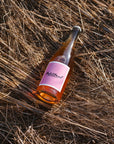 Blind Corner Organic and Biodynamic Margaret River Petillant bottle lying in the long, dried grass