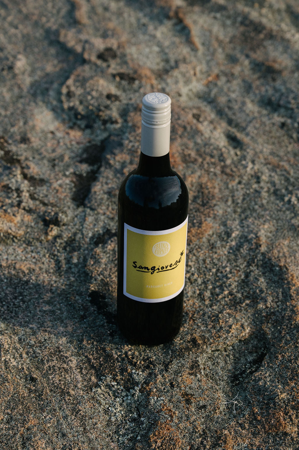 Bottle of Blind Corner Organic Sangiovese sitting on a stony surface in the Margaret River region