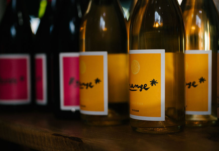 Bottles of Blind Corner wine with labels on a wooden surface