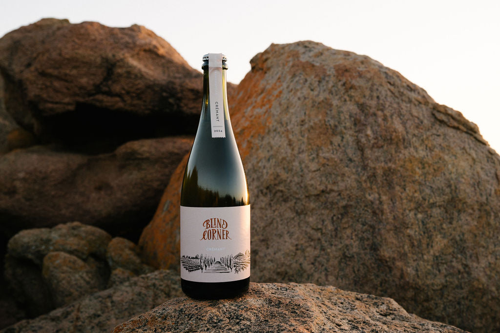 Blind Corner Organic and Biodynamic Margaret River Cremant bottle on a rock at the beach
