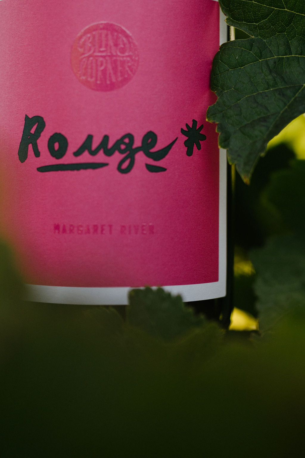 Blind Corner Organic and Biodynamic Margaret River Rouge label close-up. Vine leaves frame the pink label