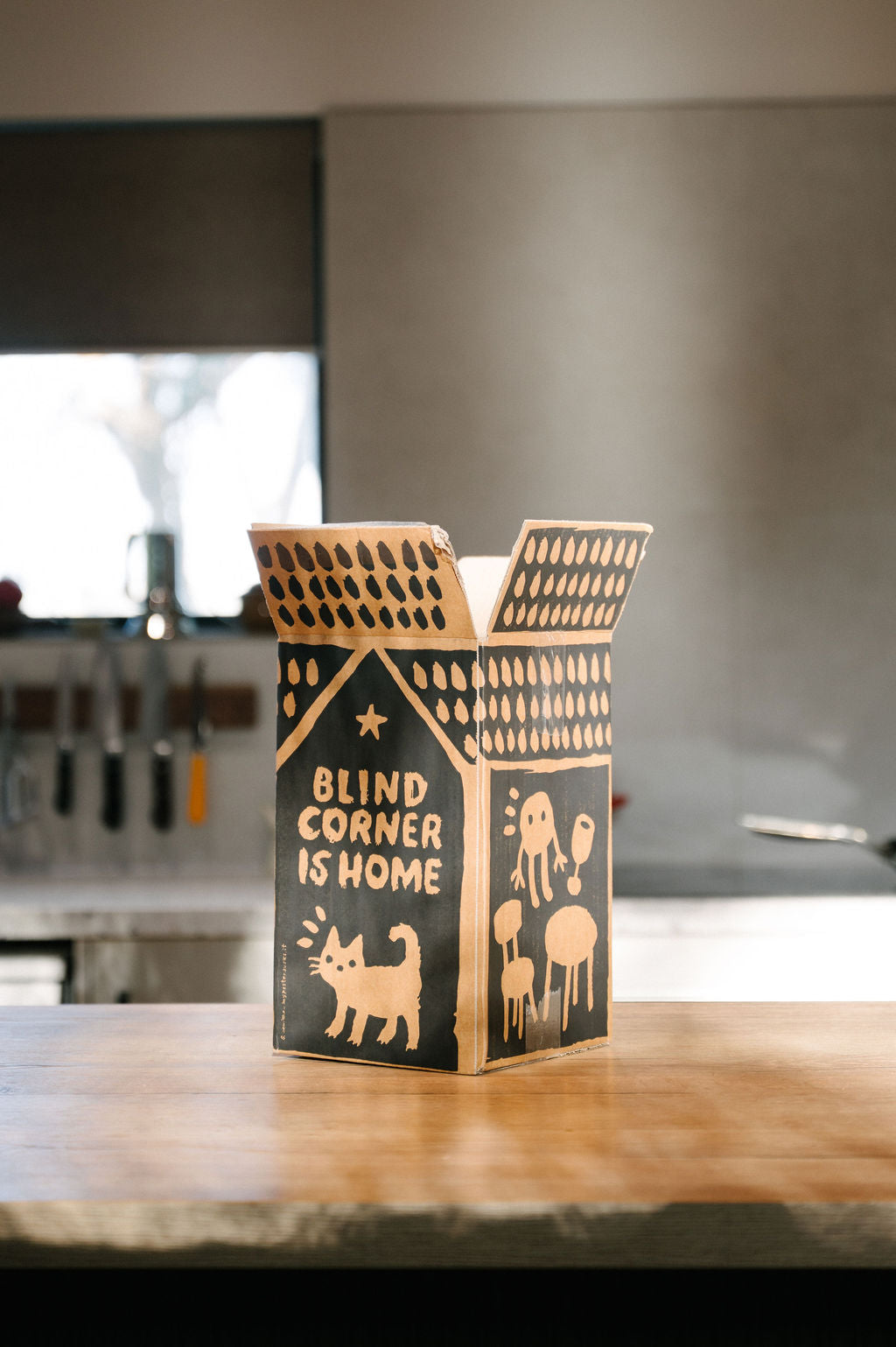Blind Corner Wine Club box opened on a kitchen bench with 'Blind Corner is Home' text on the side