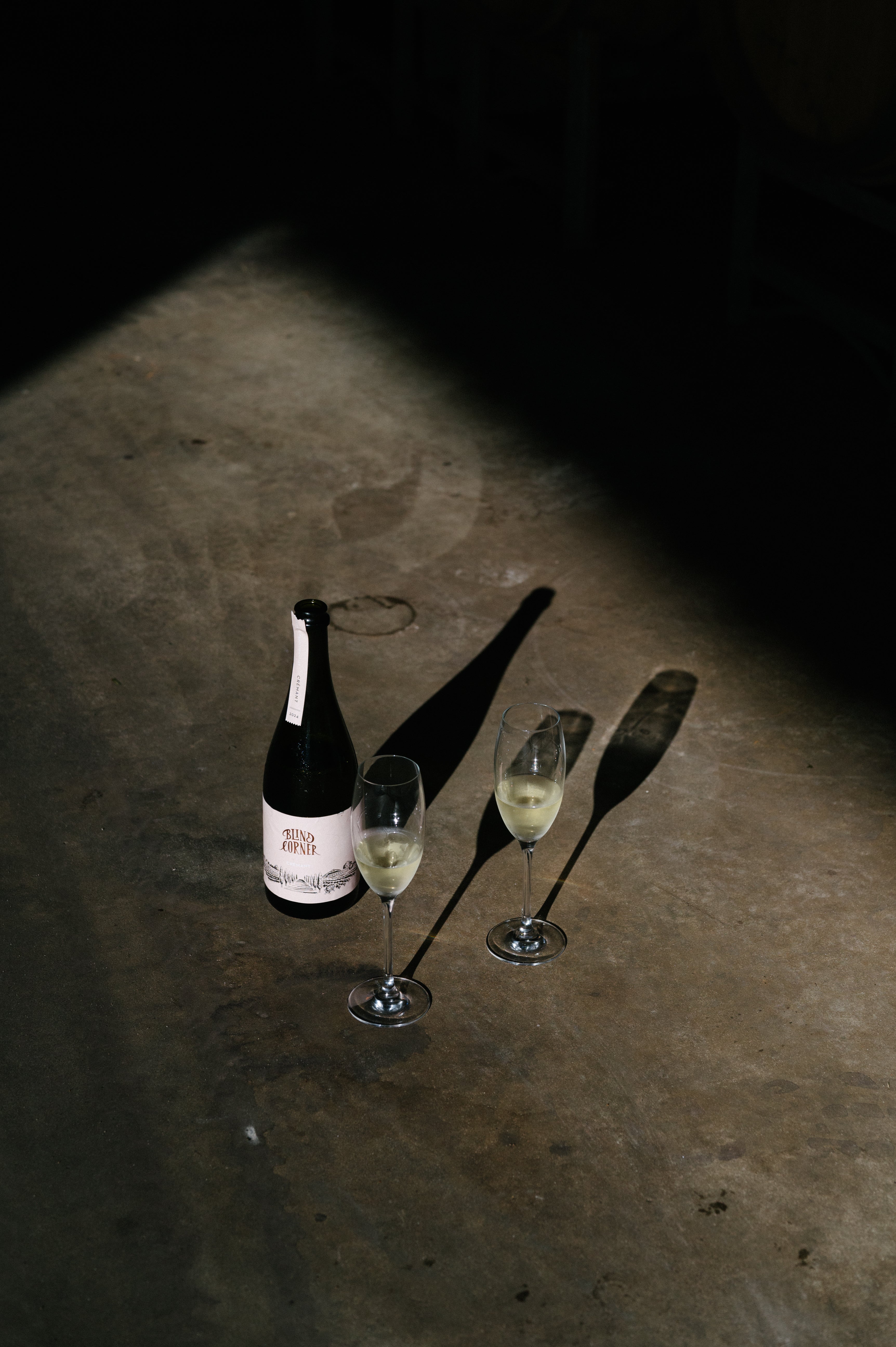 Bottle of cremant with two glasses on a dark surface
